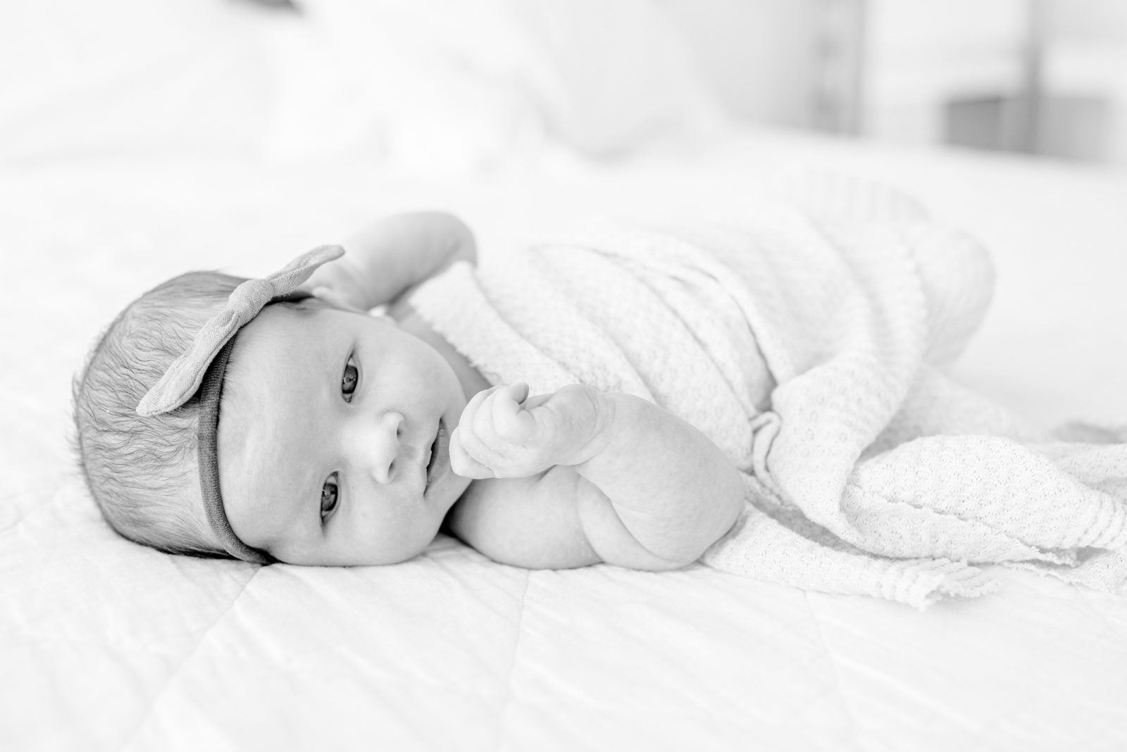 Black and white newborn portrait on the bed during a lifestyle newborn session