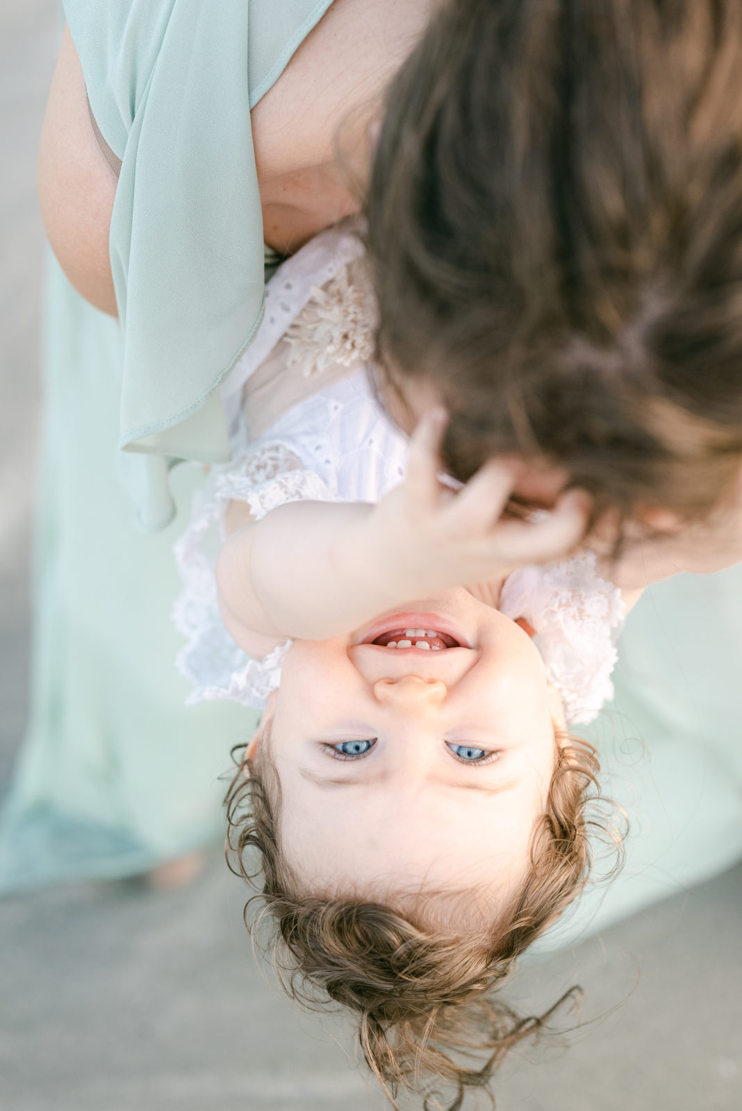 Blue eyed baby upside down laughing for her milestone session 