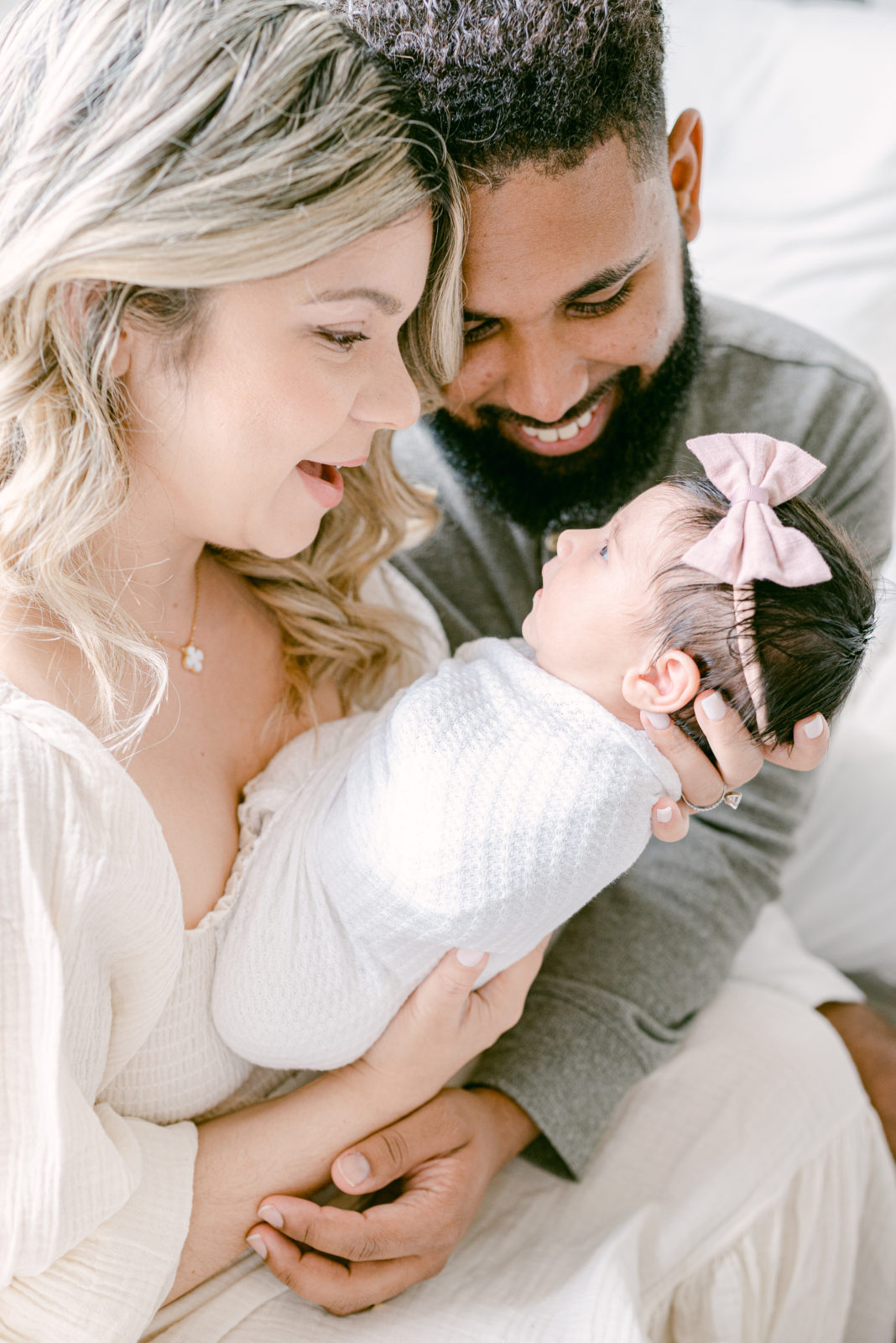 Parents holding and smiling at their newborn baby girl 