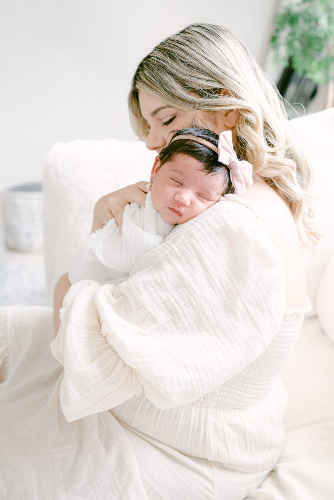 Mom holding newborn baby girl sleeping on her chest at home newborn photos