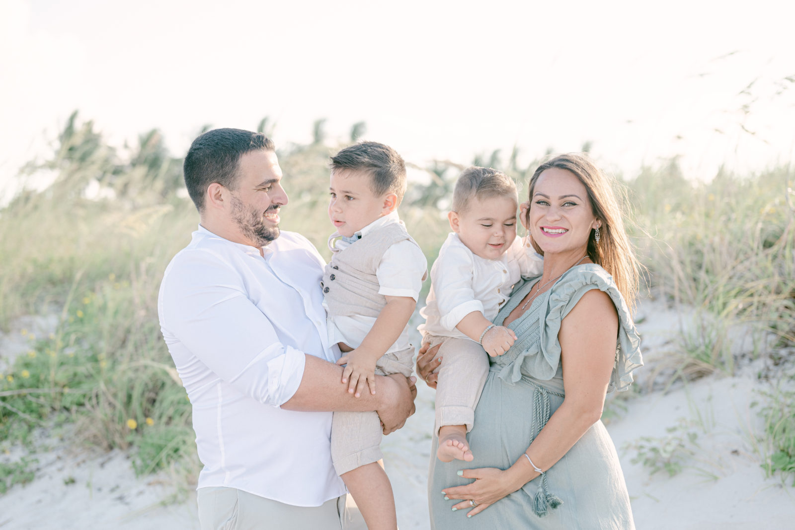 growing family portrait with two toddlers during sunset maternity session