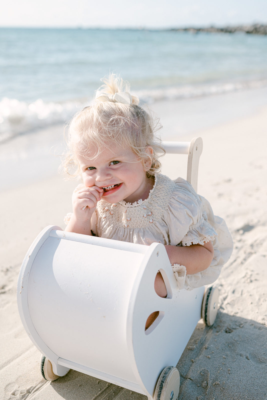 Family session on the beach of toddler in basket