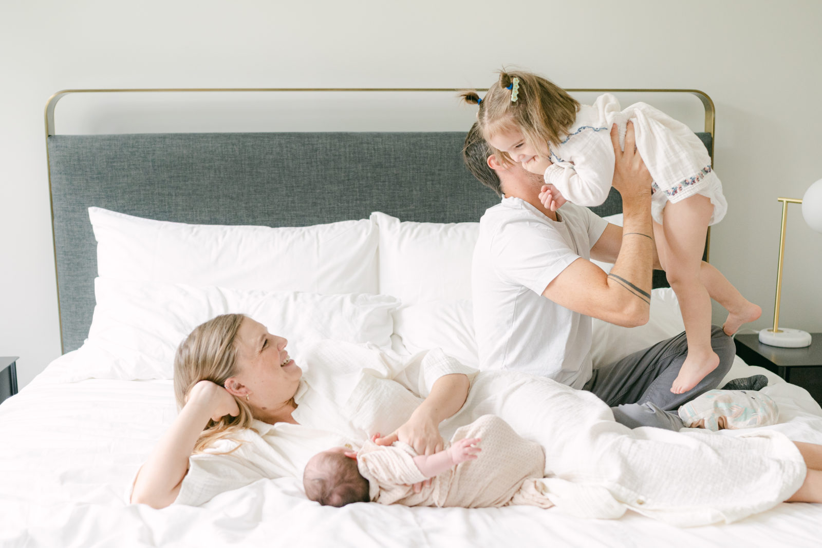 At home Newborn Photos family laughing on the bed