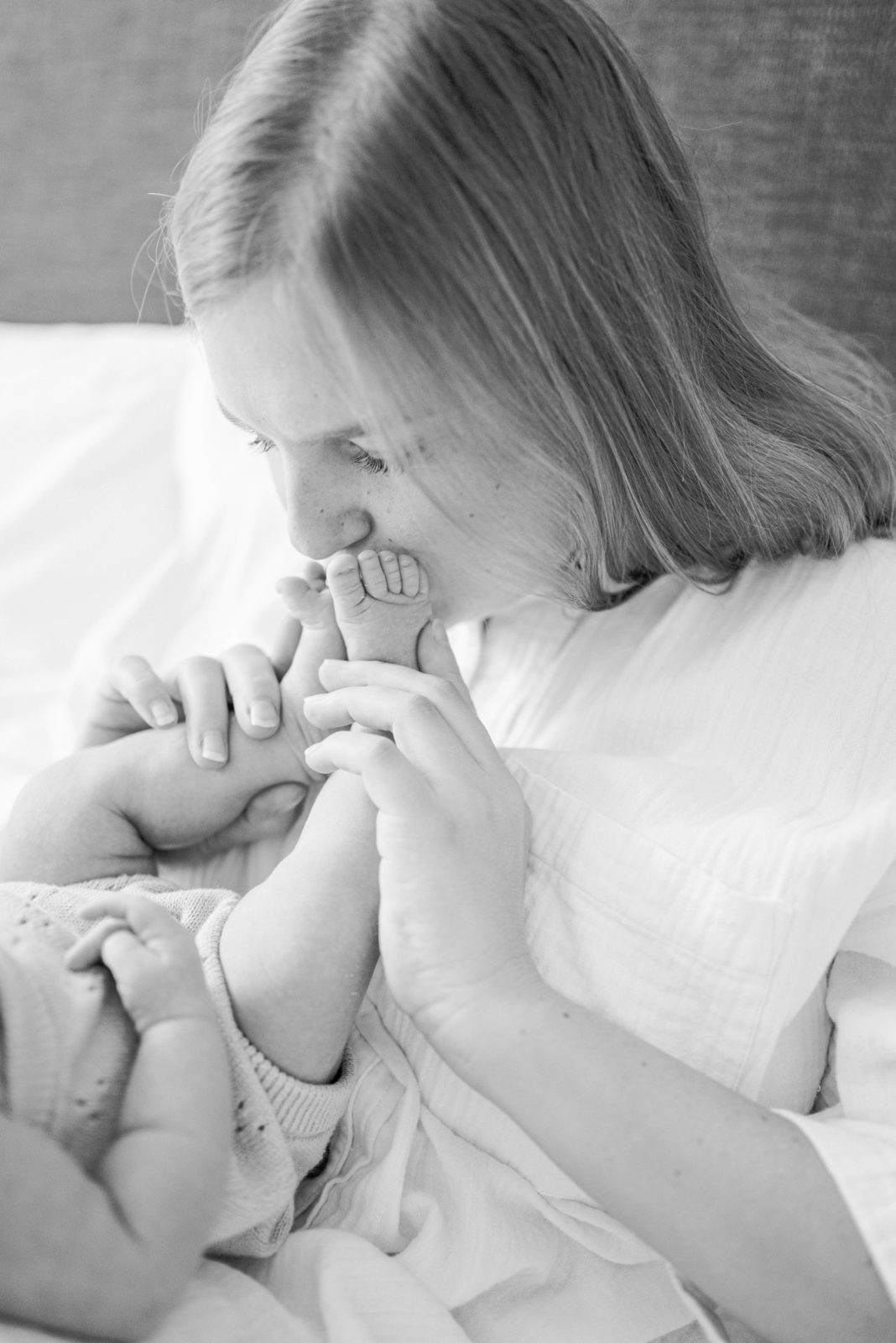 At home Newborn Pictures with Mom Kissing Baby Feet