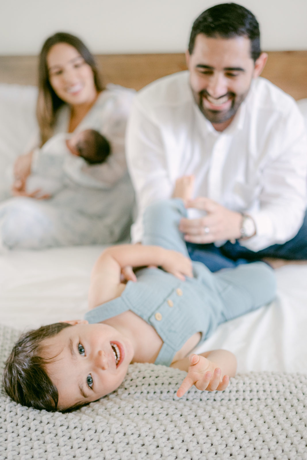 Dad tickling his toddler during newborn session