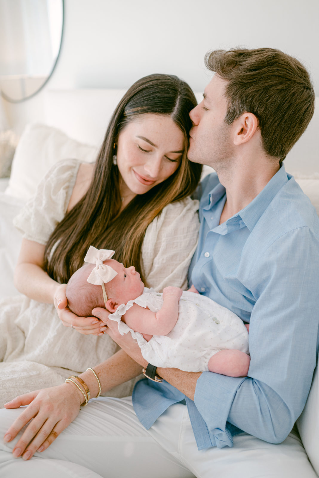 Dad kissing mom on the forehead during their dreamy at home newborn session