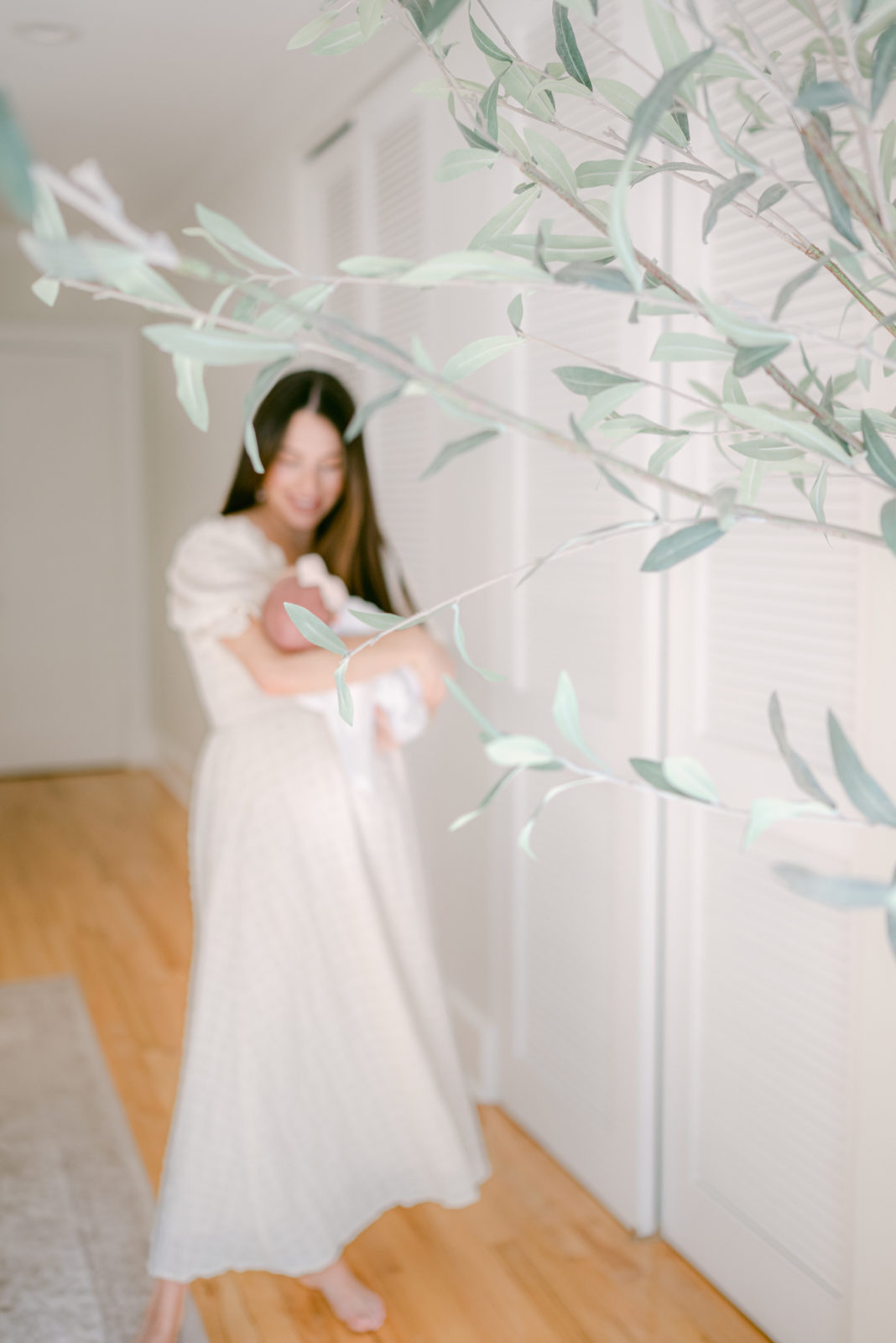 Dreamy, out of focus photo of mom rocking her newborn baby at home