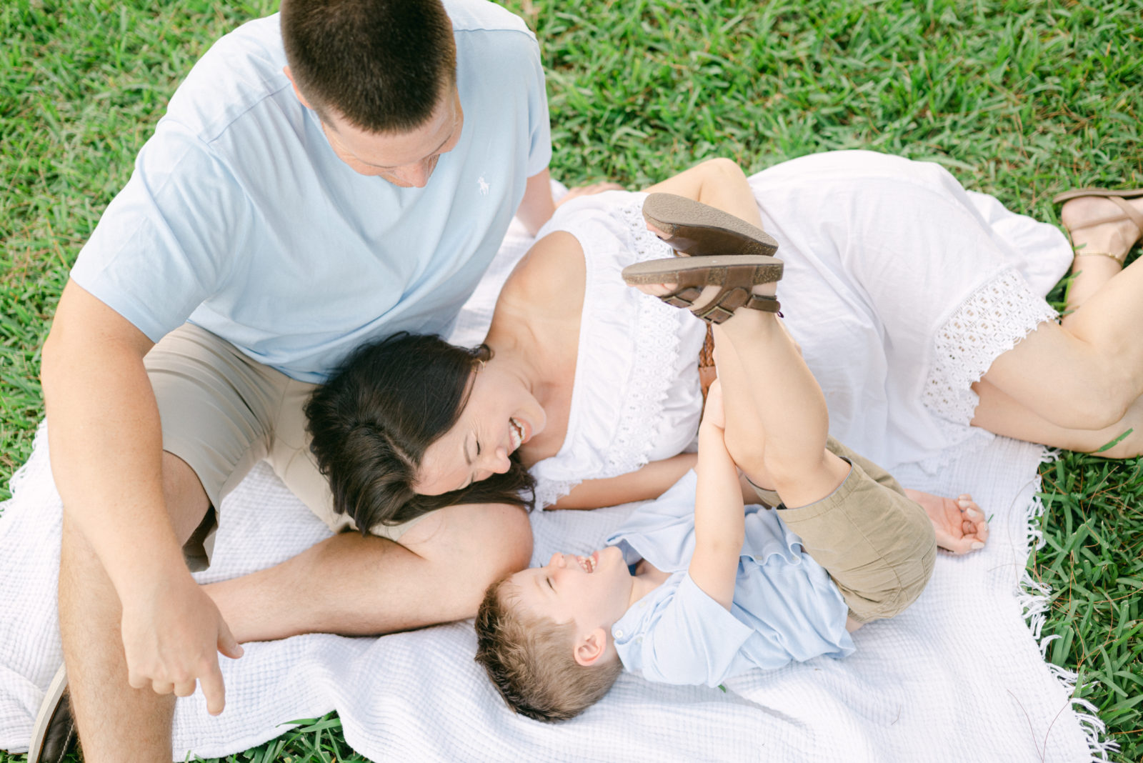 Family playing together on a blanket in a park