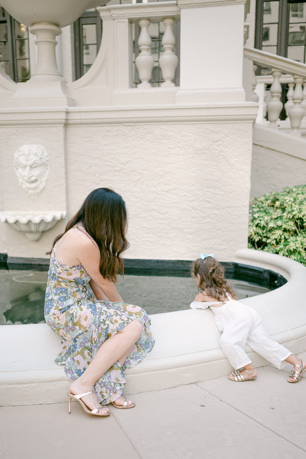 Mom and daughter touching the water in the fountain at The Breakers