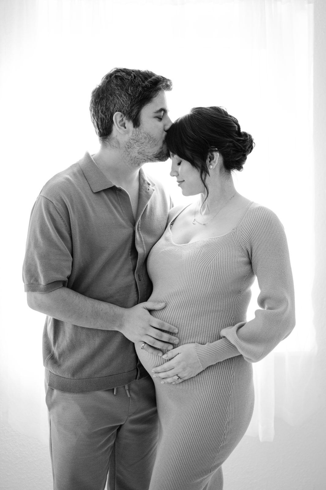 Husband kissing pregnant wife on her forehead