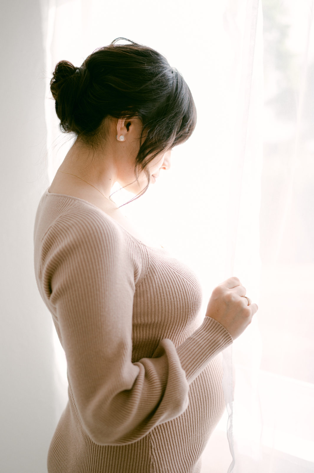 Pregnant woman looking out through the window