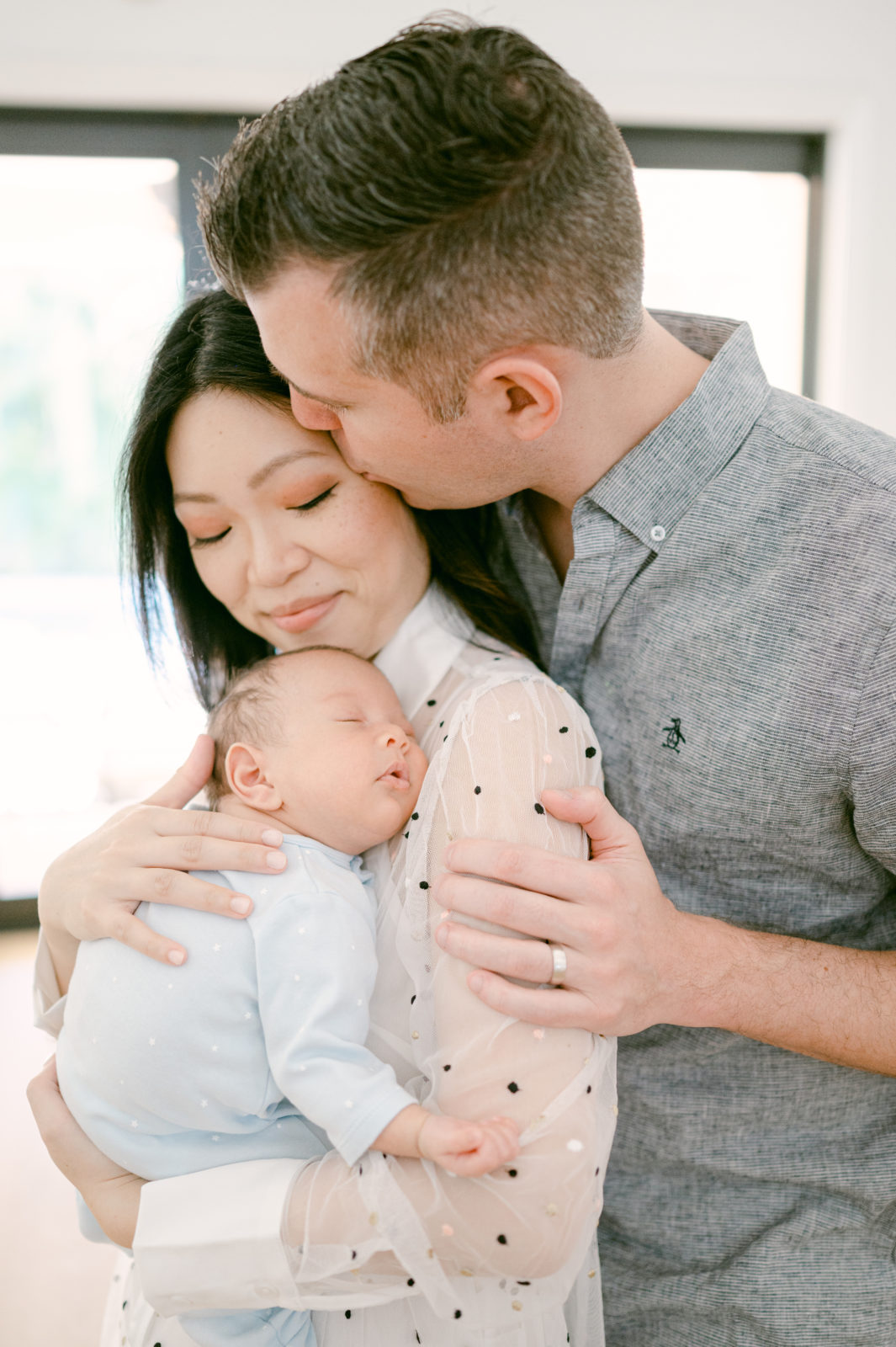 Mom and dad holding their newborn baby boy by Miami Baby Photographer