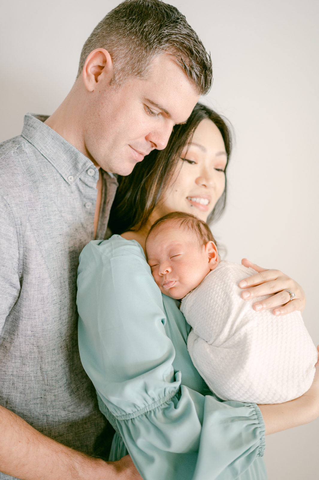 New family portrait of dad, mom and newborn