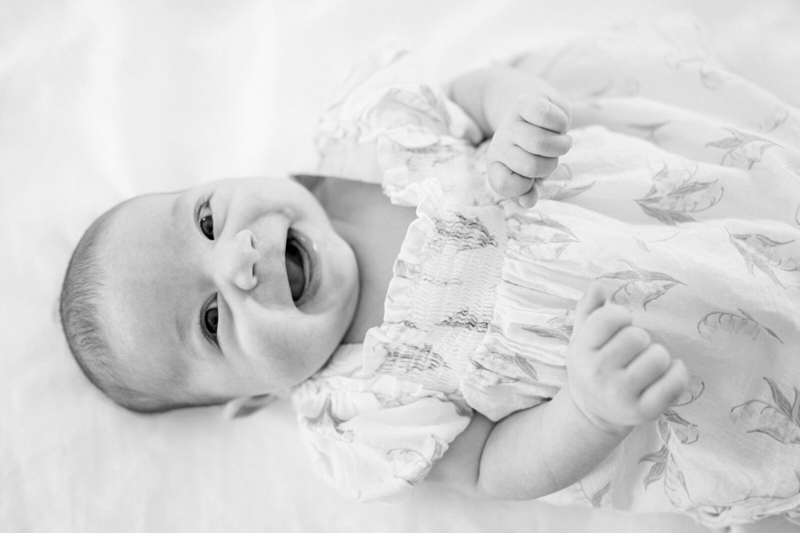 2 month-old baby girl smiling during her newborn photos