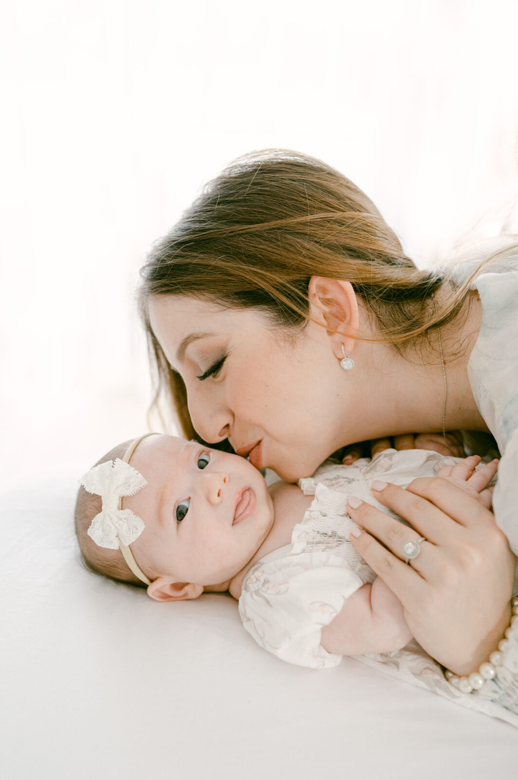 Mom kissing her baby girl during miami newborn photos