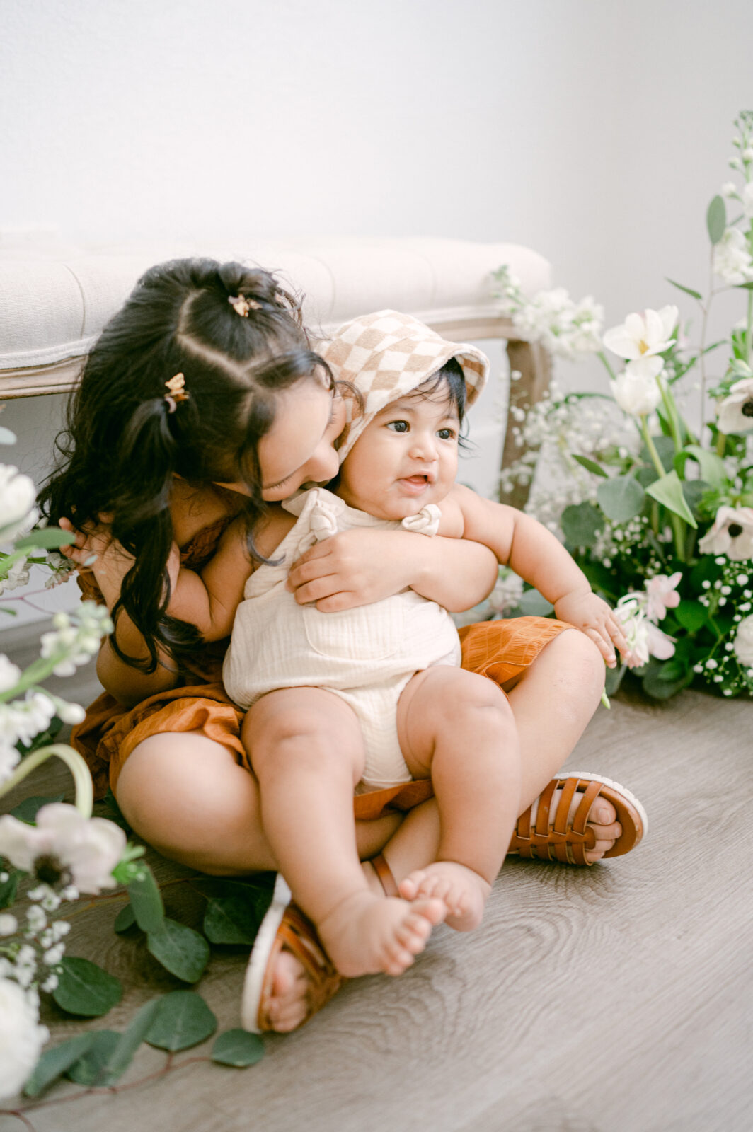 Big sister hugging little brother during Mother's day mini sessions in Miami