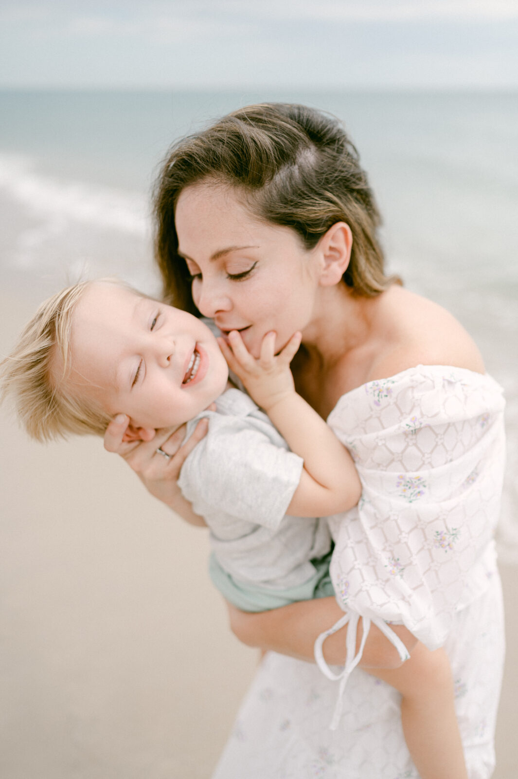 Mom kissing her little boy on the beach