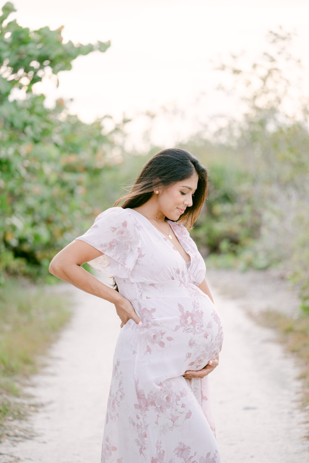 Maternity photos in Key biscayne of mom looking down her baby bump