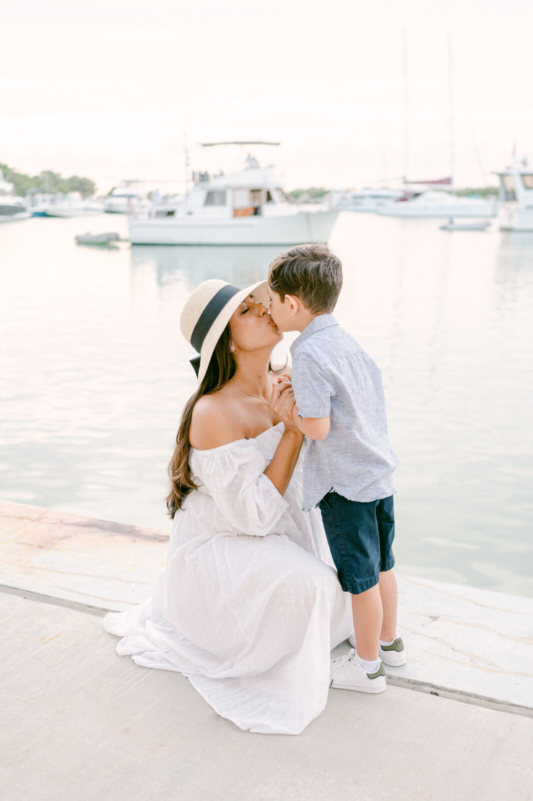 Mom and child kissing with boats in the background by Miami Family photographer 