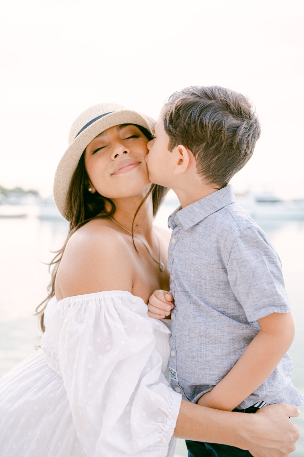 Child kissing mom during maternity session in Key Biscayne