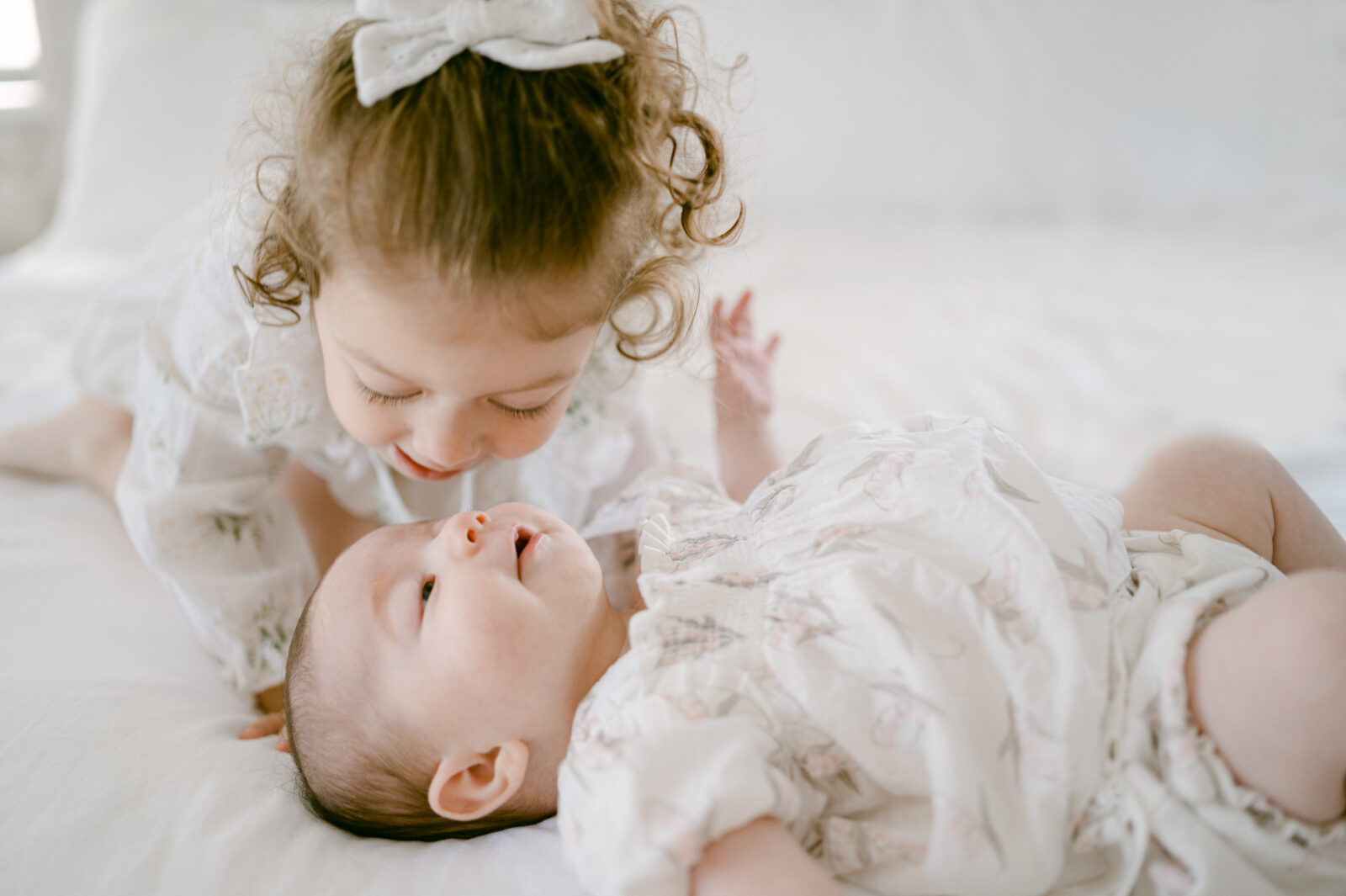 Big sister kissing her newborn baby sister in Miami