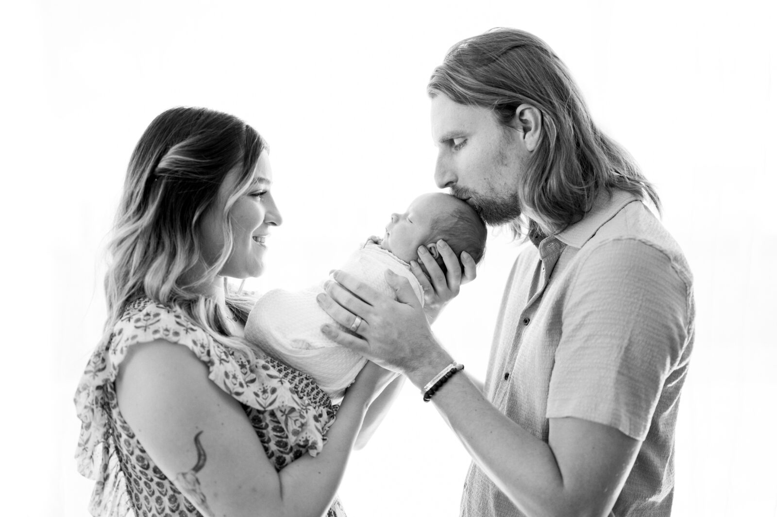 Black and white portrait of dad and mom with their new addition during their Miami newborn session