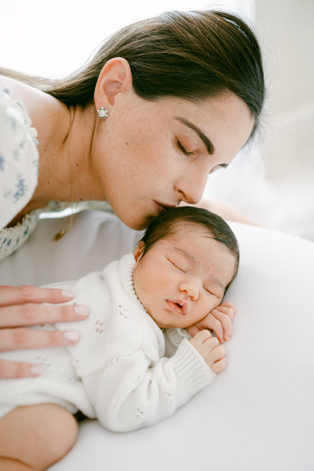 Mom kissing her newborn baby boy by Miami Newborn Photographer