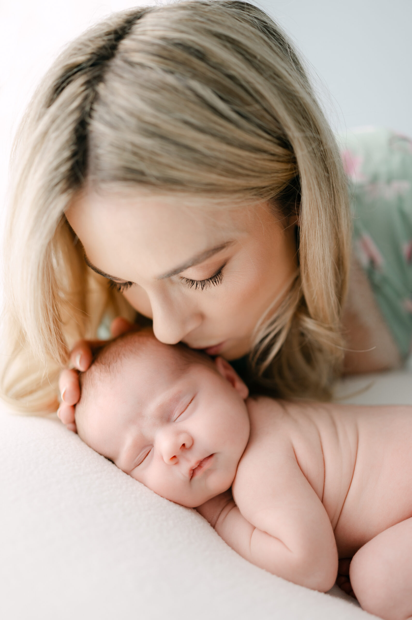 Mom kissing her newborn baby during her Miami photoshoot