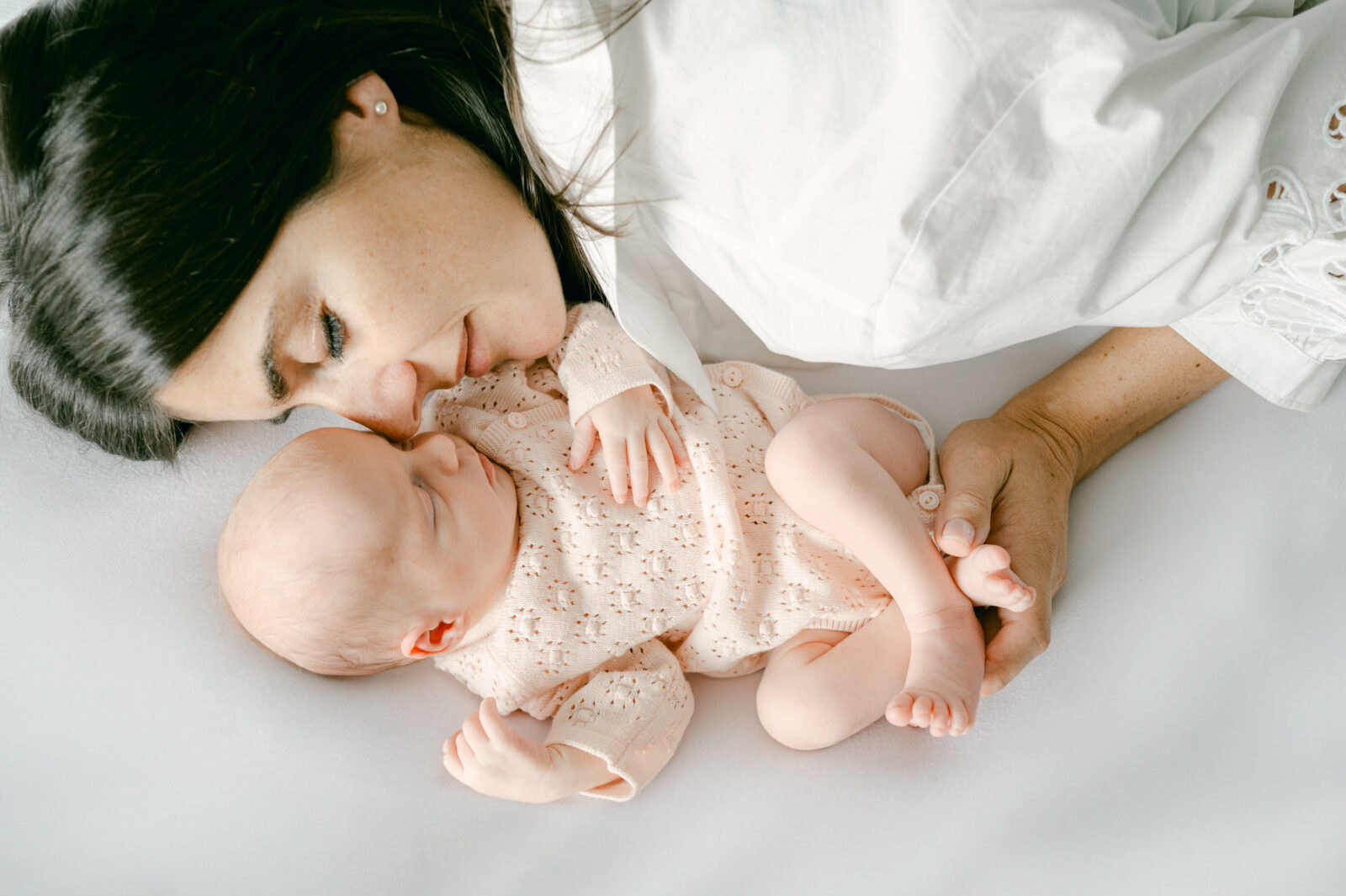 Mom snuggling with one of her twin girls during her Miami newborn session