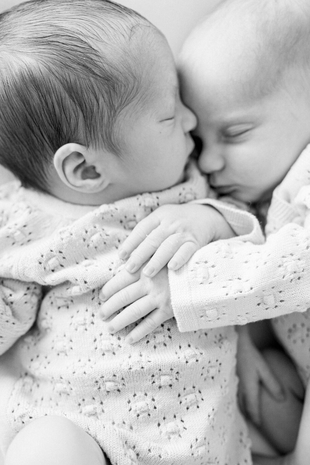 Twin newborns snuggling together
