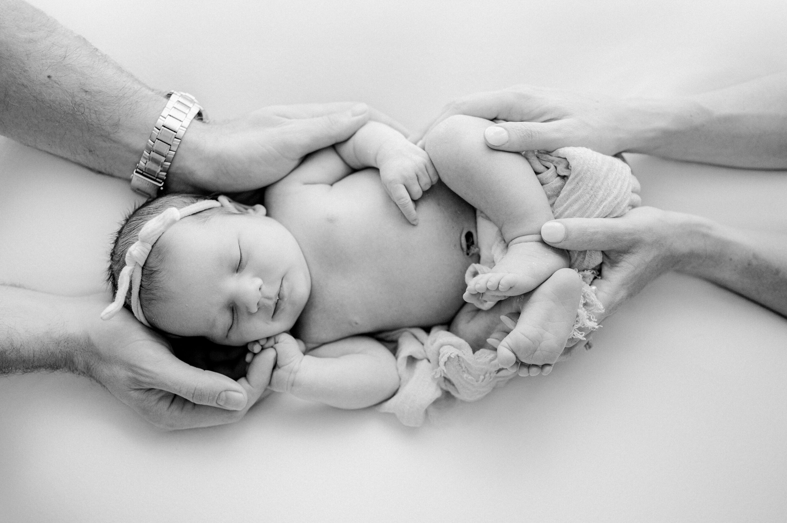 Black and white newborn photo with hands