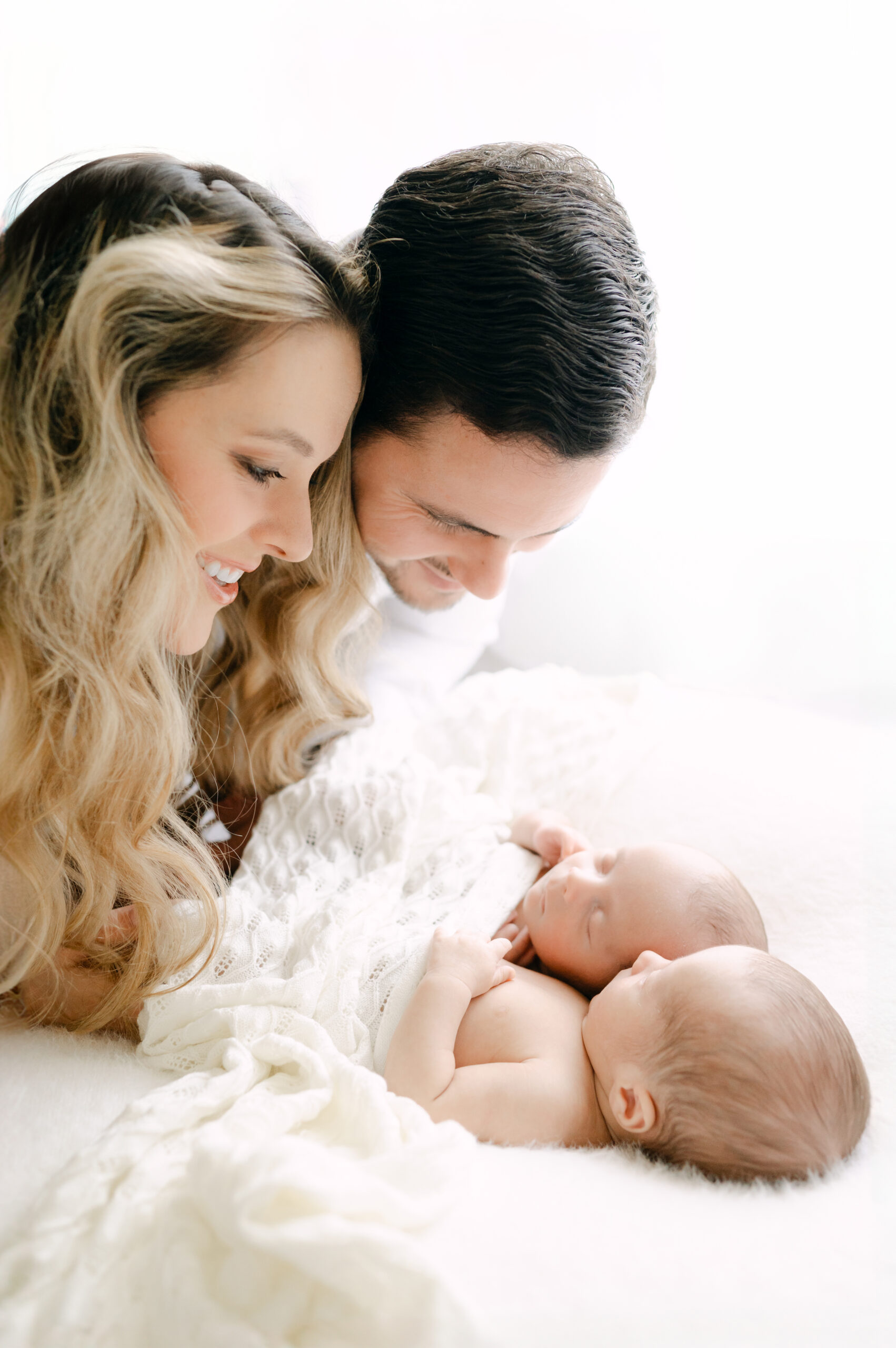 Dad and mom looking down at their twin babies