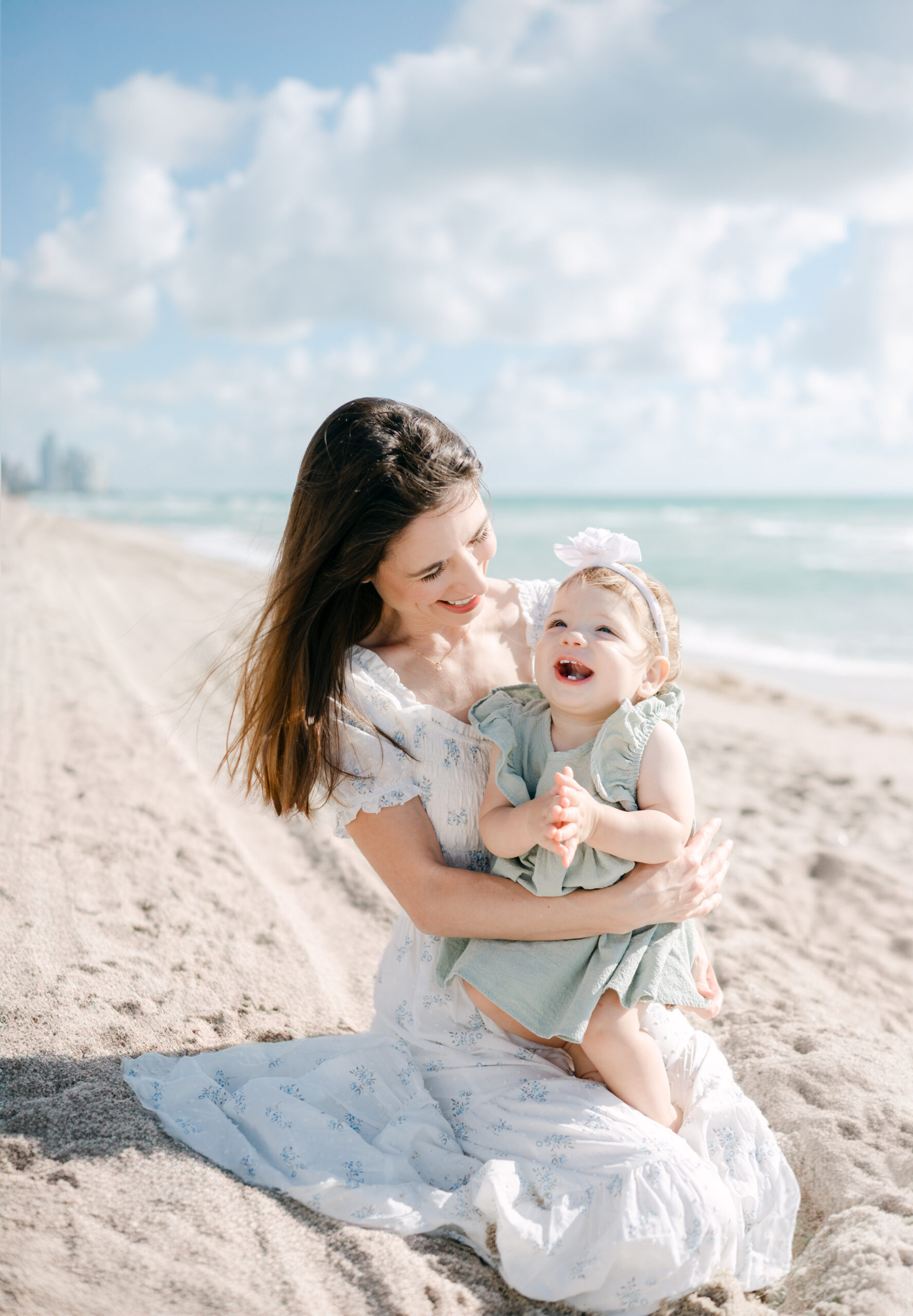 Mom and baby laughing at the beach