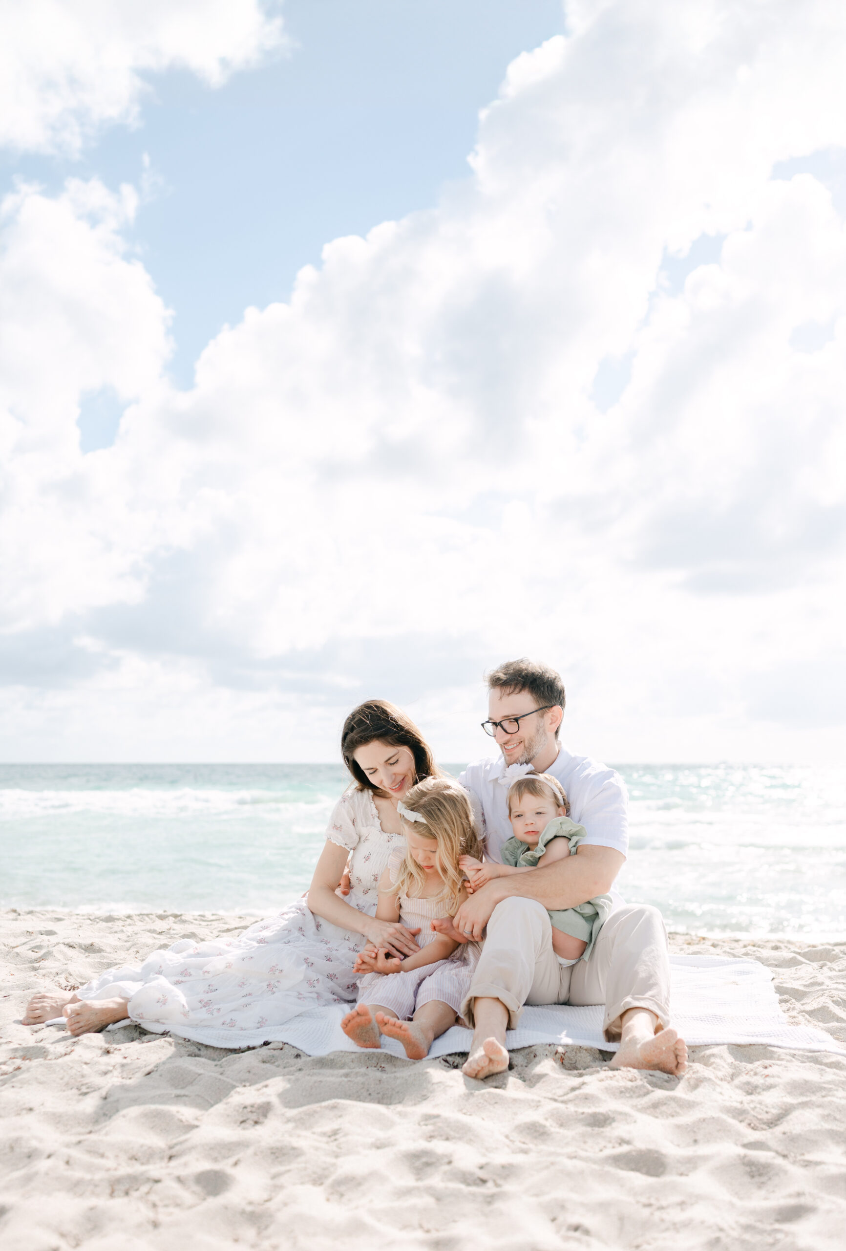 Family sitting on the sand and snuggling