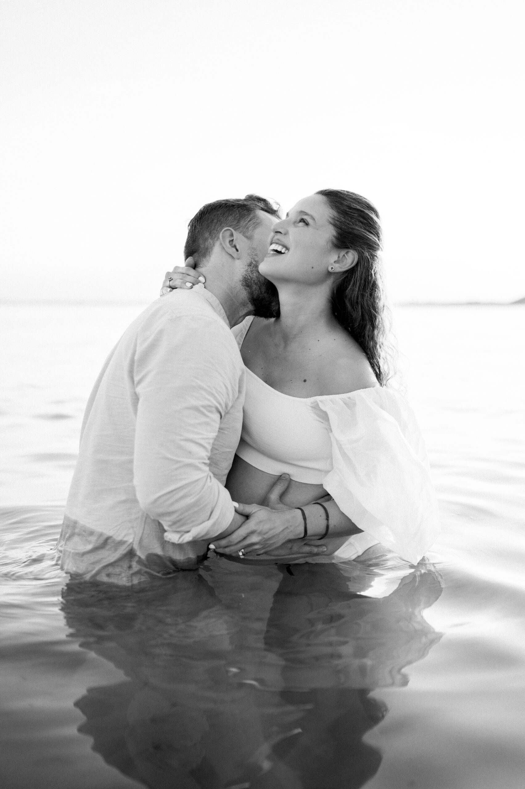 Pregnant couple laughing in the Miami water