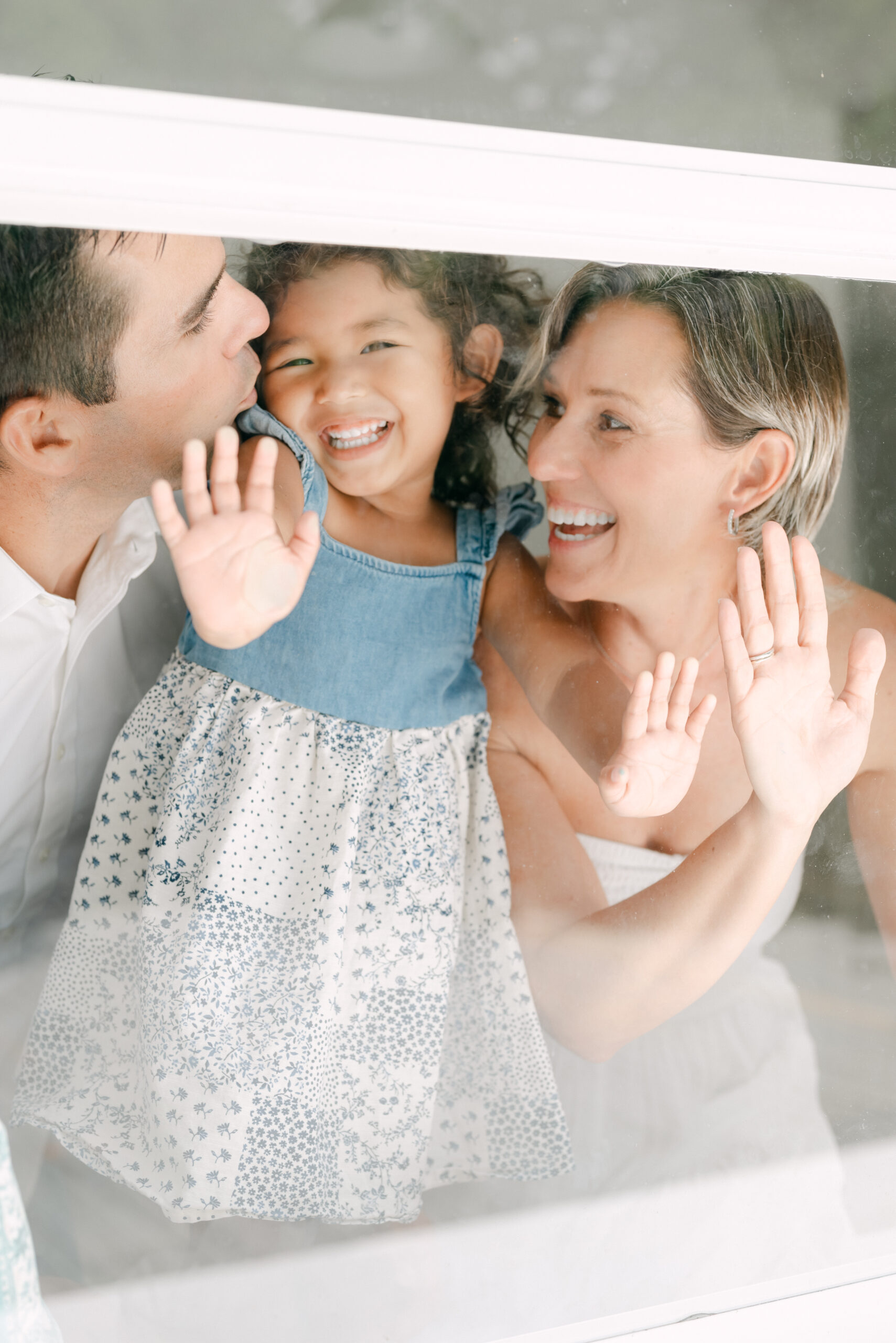 Family giggling at the window during Miami family photos