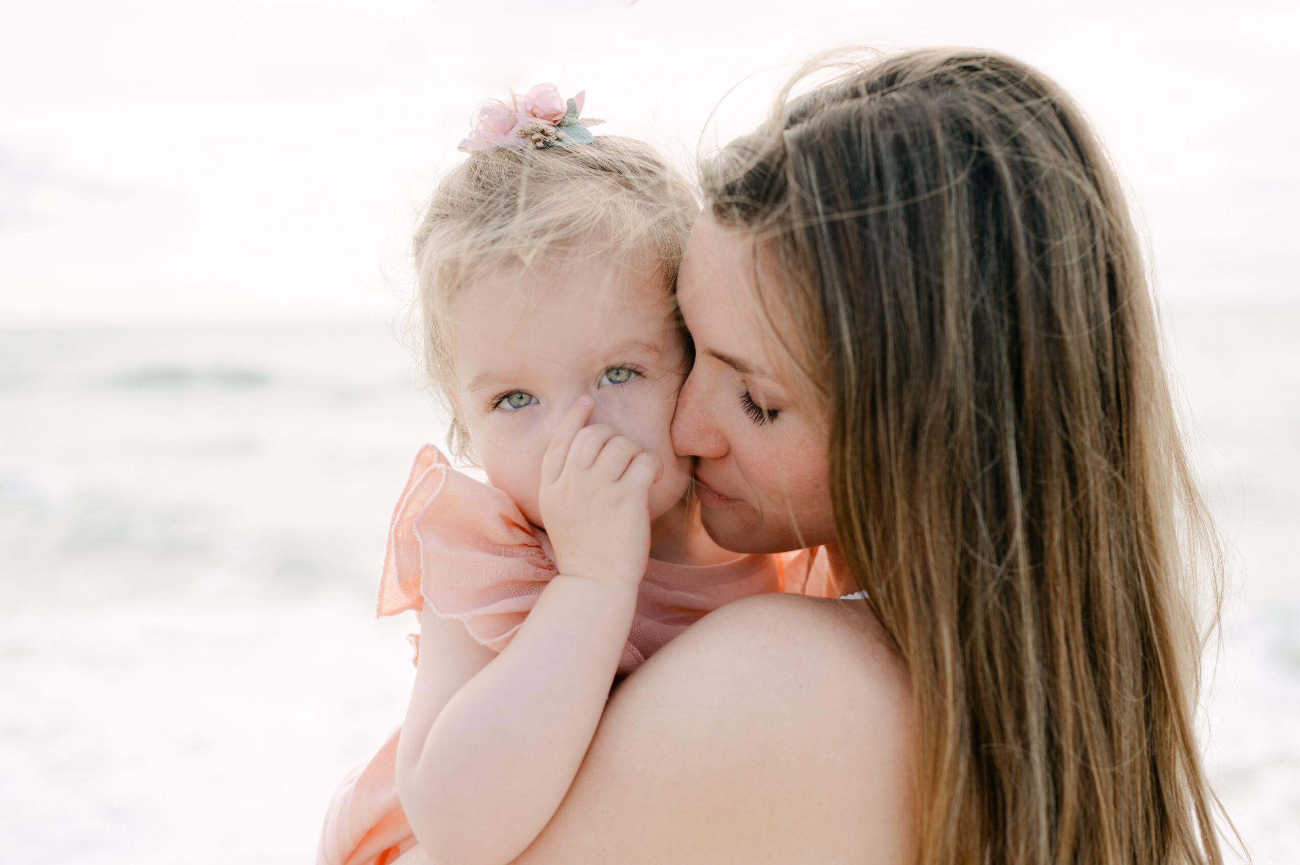 Mom snuggling with her baby at the beach