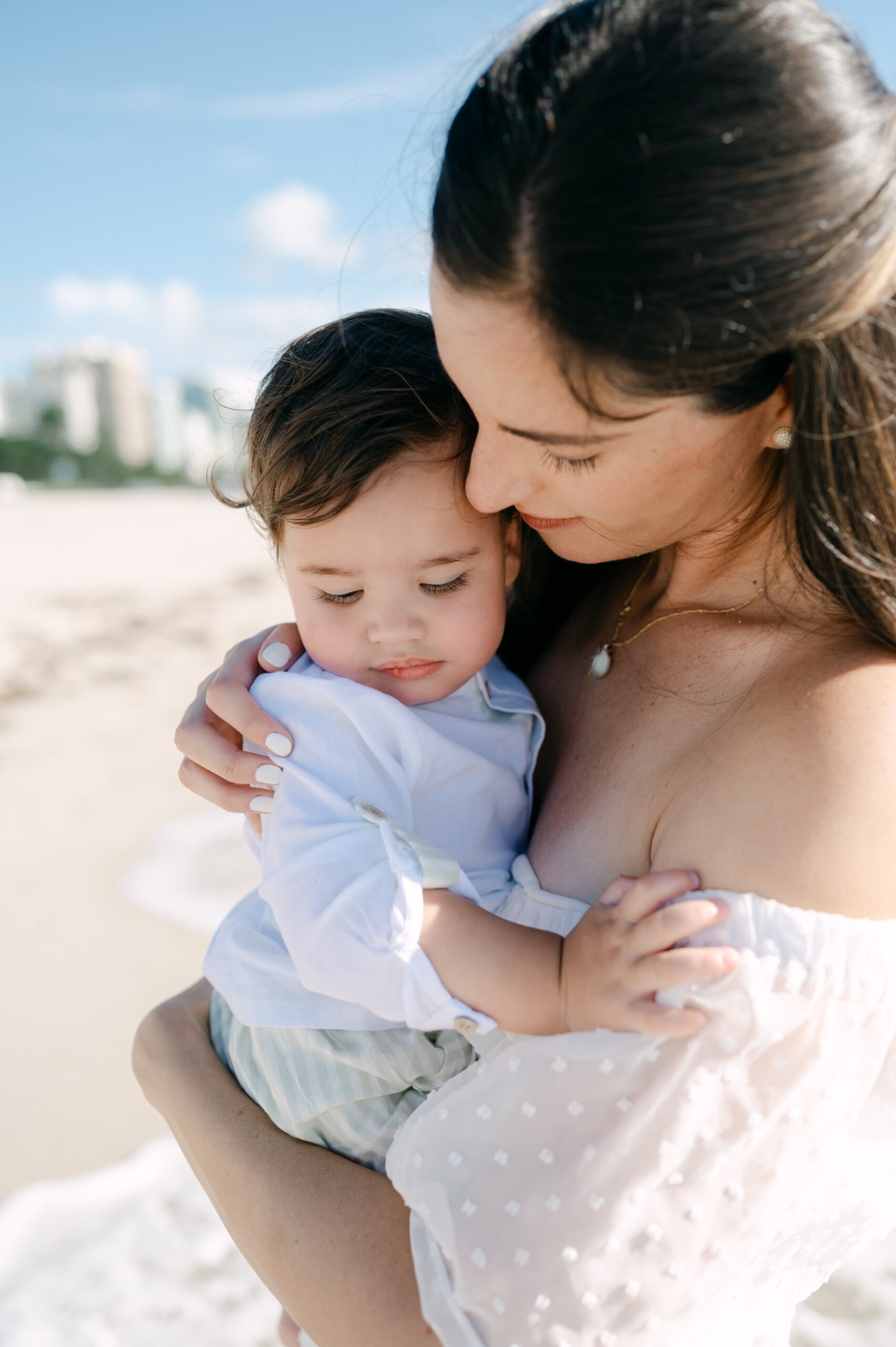 Mom snuggling with her baby at the beach