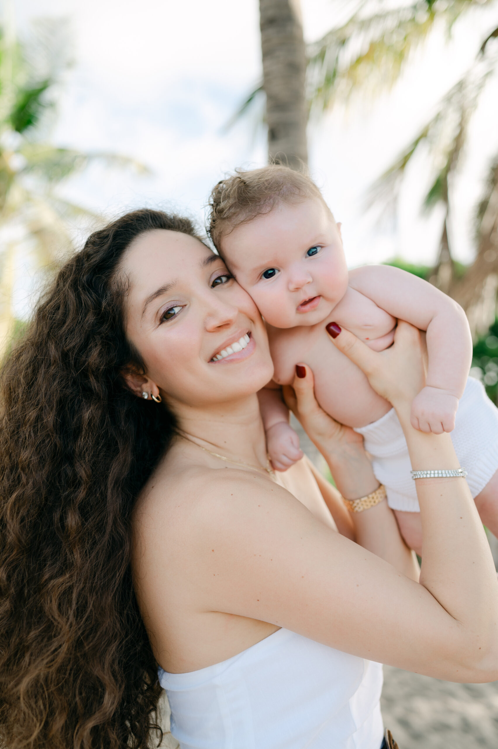 Mom and baby portrait at the beach with palm trees