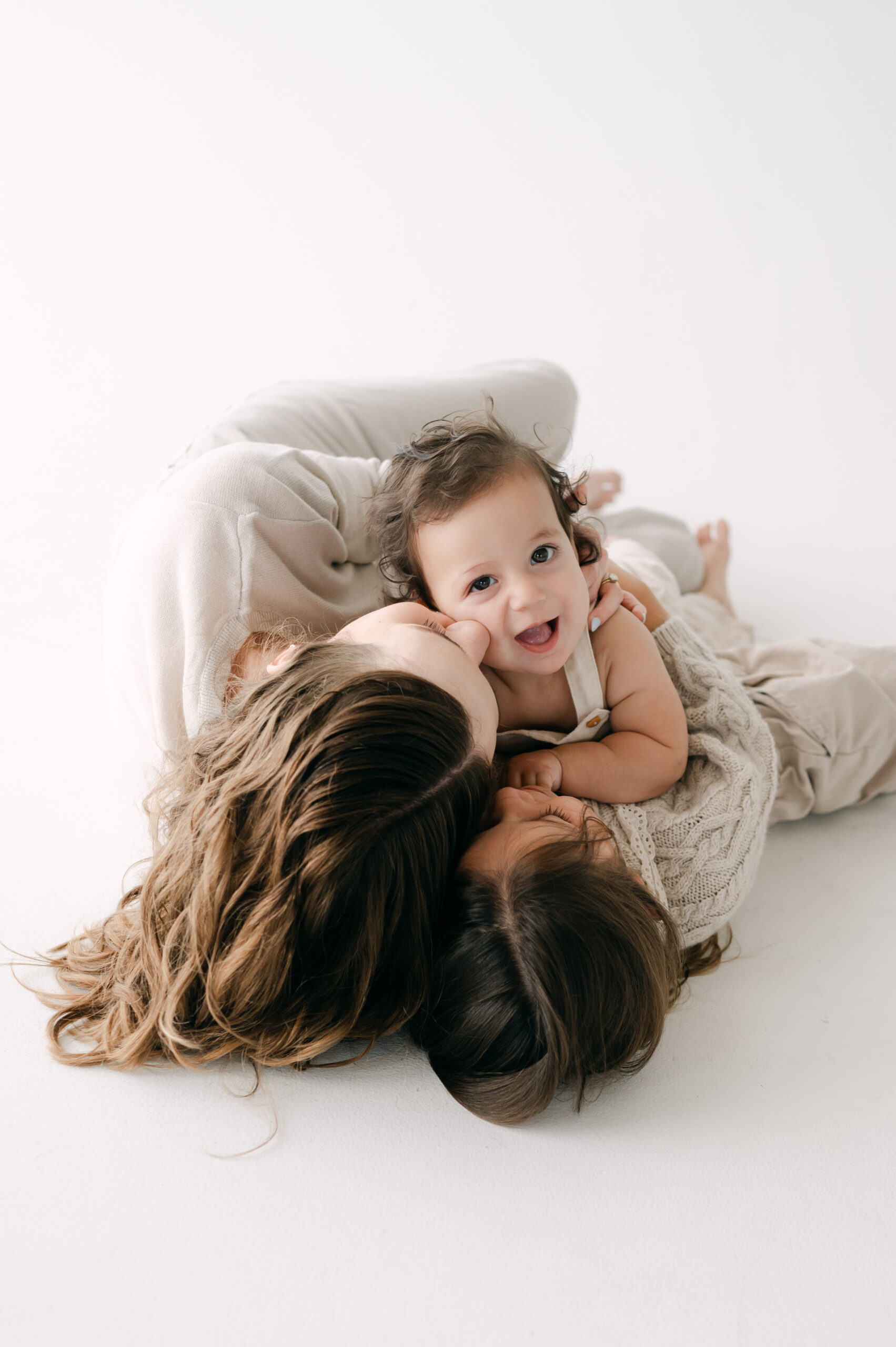 Mom and her kids snuggling on the floor in white Miami studio