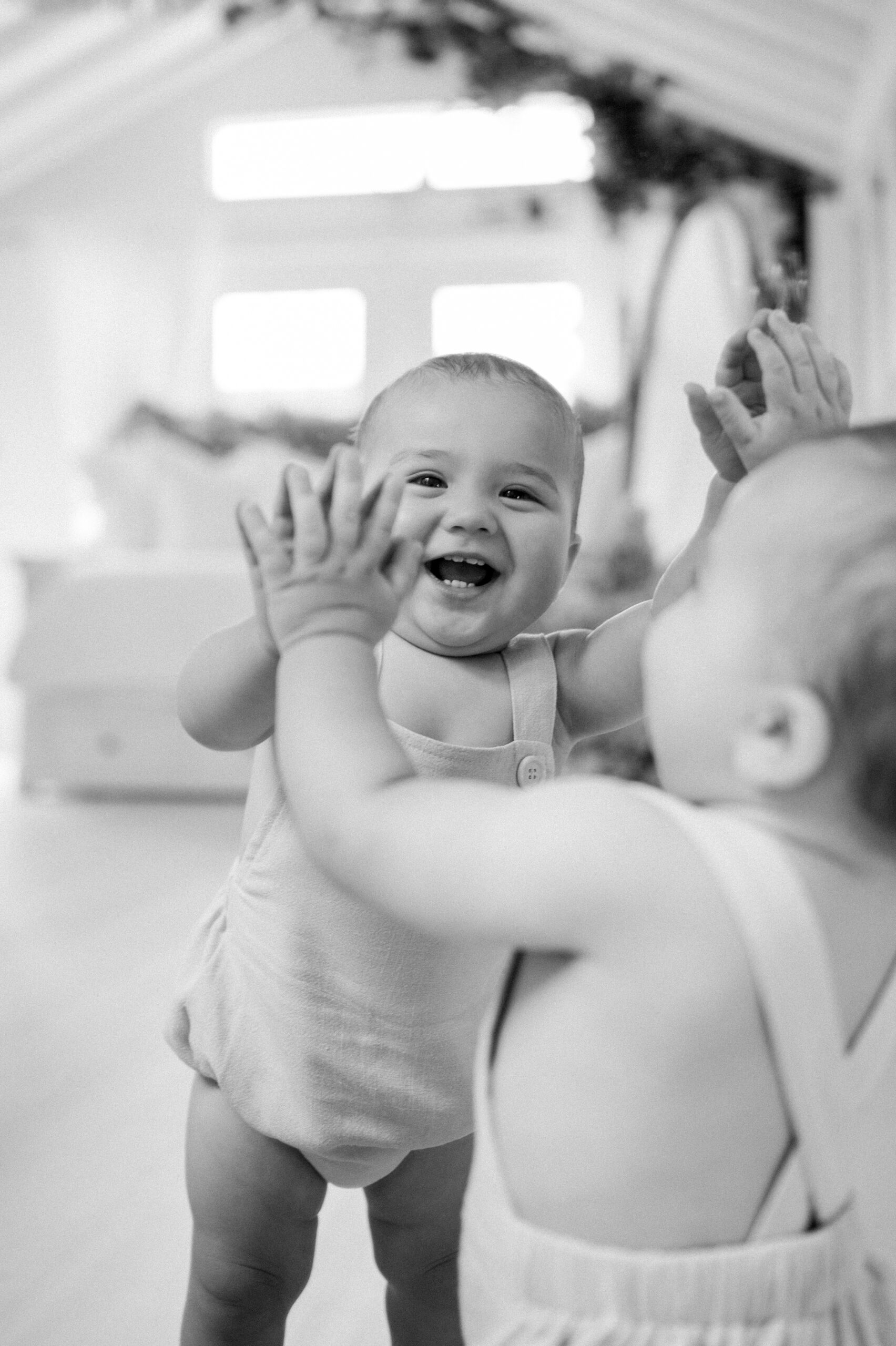 Happy baby looking at himself in the mirror