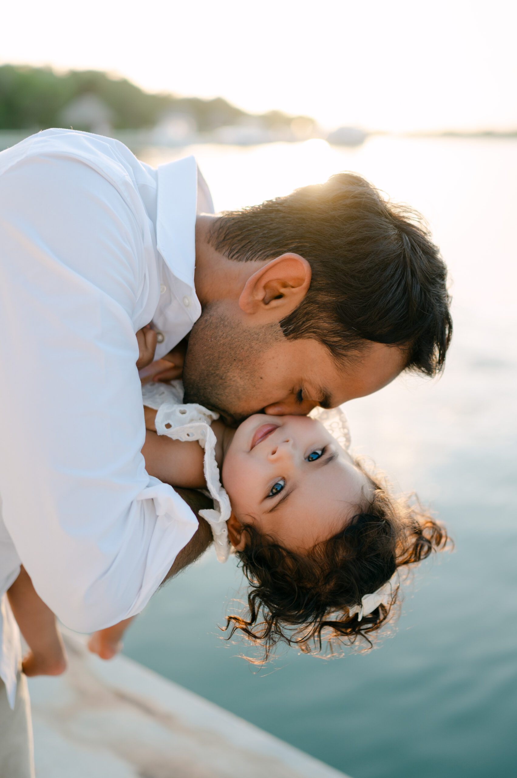 Dad throwing raspberries in daughter's neck during Miami sunset