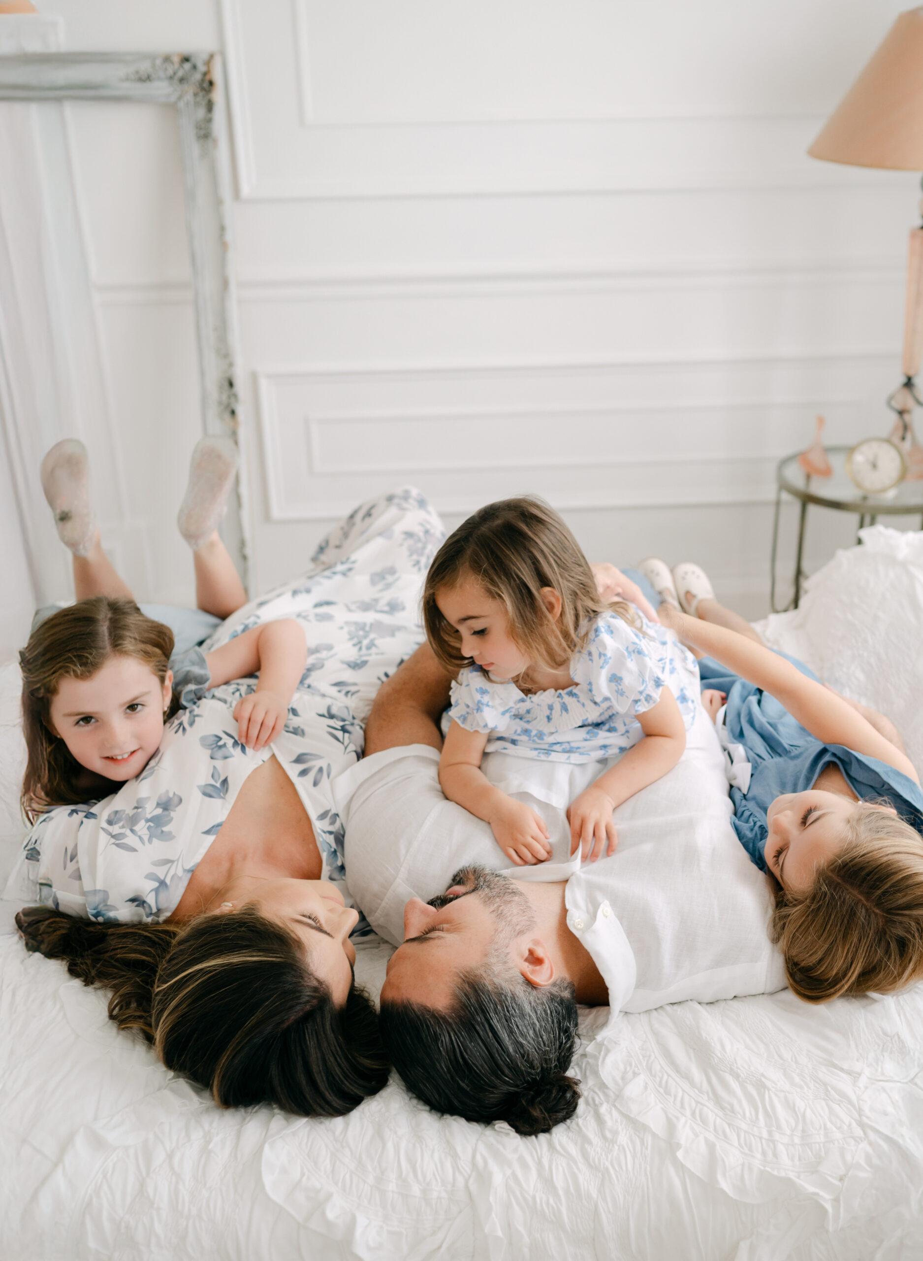Family of 5 hugging on the bed 