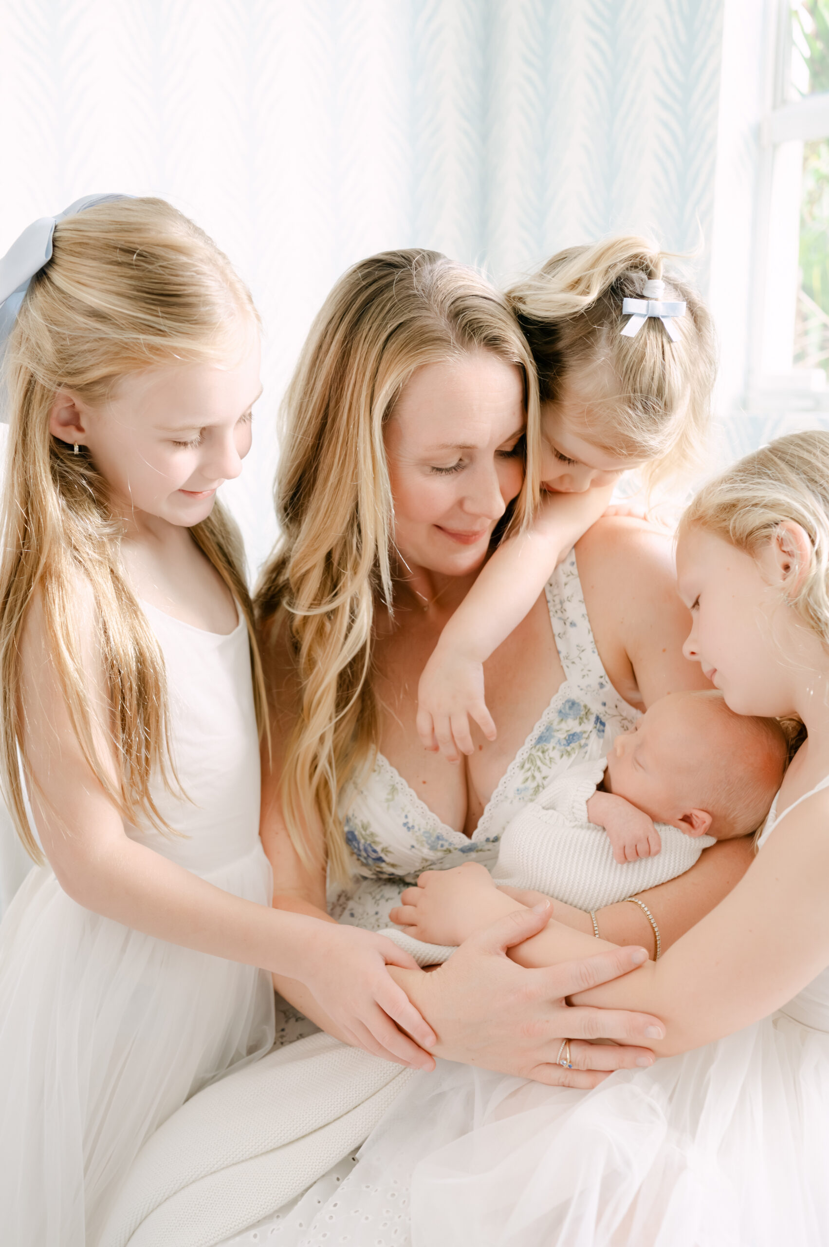 Mother and children looking at baby at home lifestyle session 